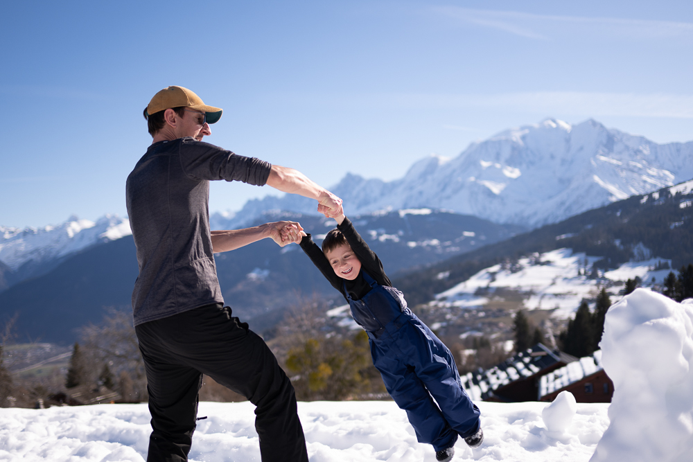 Père et enfant jouant dans la neige face au Mont-Blanc – séance photo famille Combloux