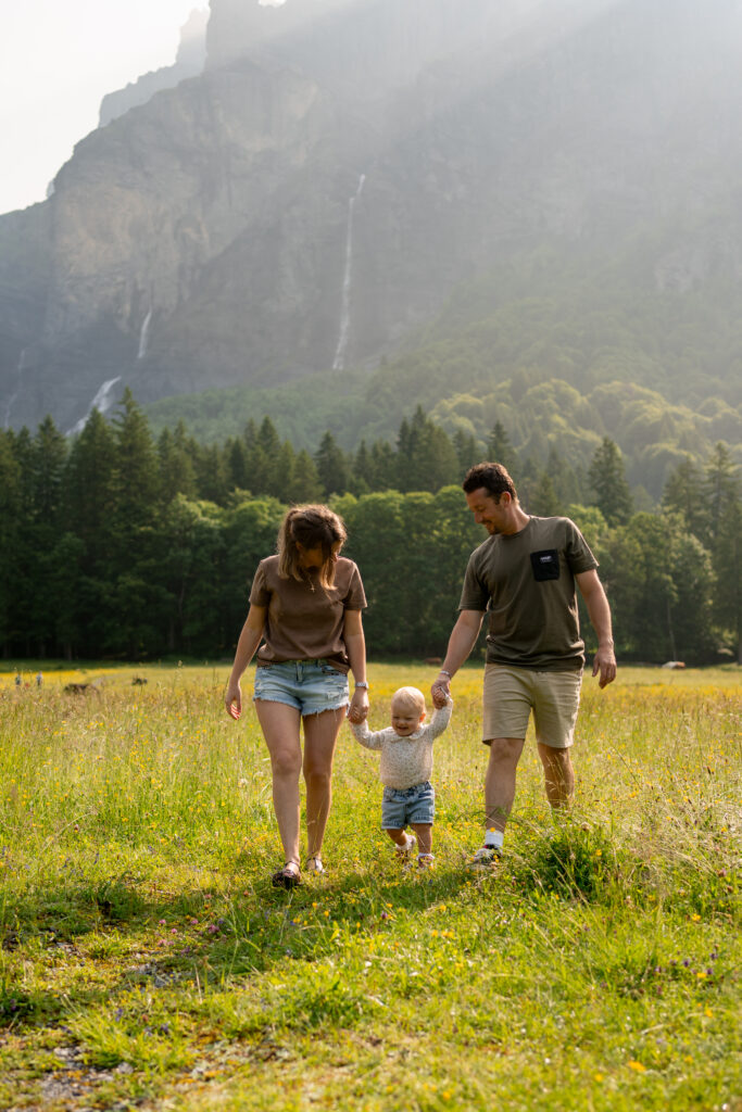 famille avec enfant marchant dans un champ au cirque du Fer-à-Cheval à Sixt séance photo famille vallée du Giffre