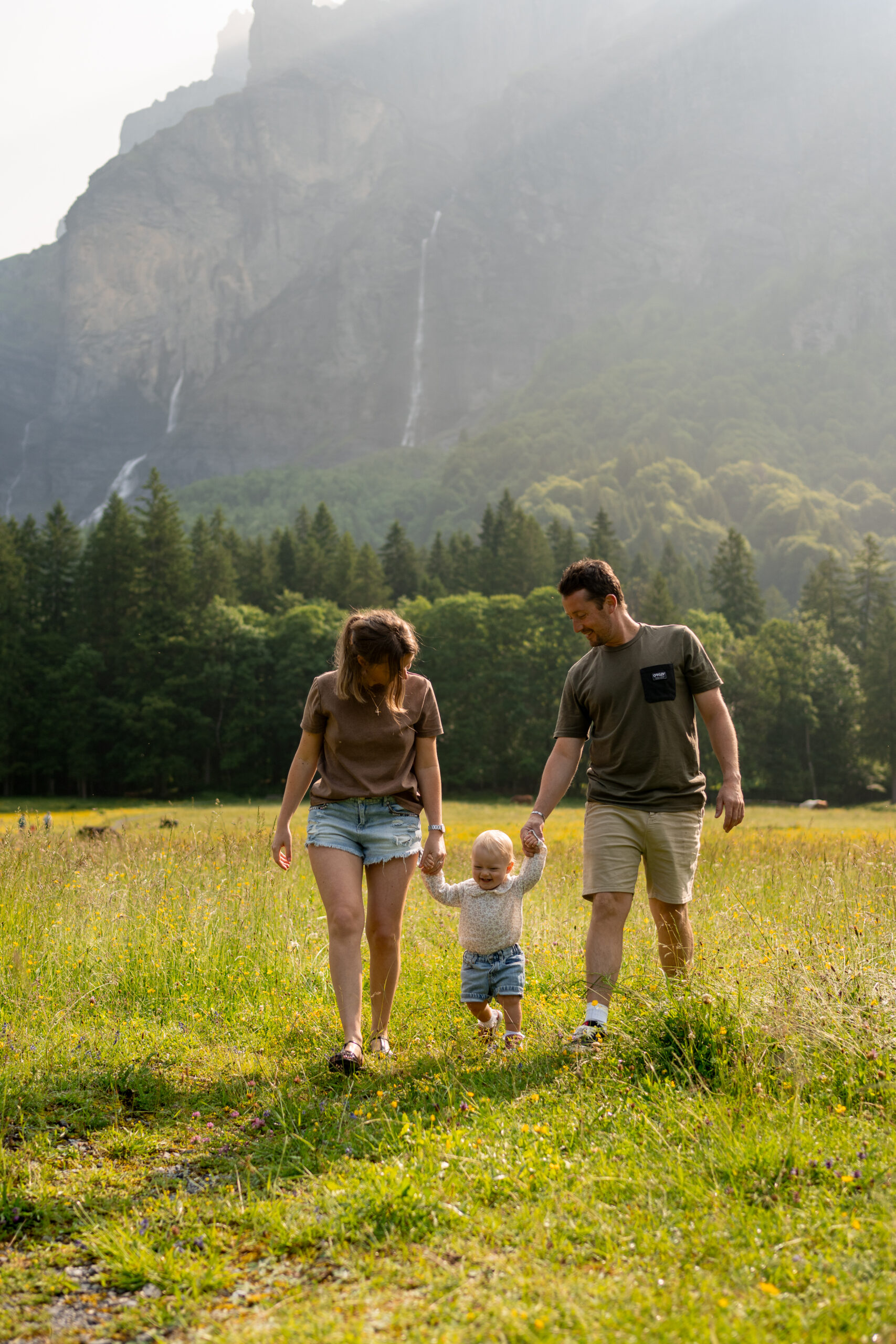 famille avec enfant marchant dans un champ au cirque du Fer-à-Cheval à Sixt séance photo famille vallée du Giffre