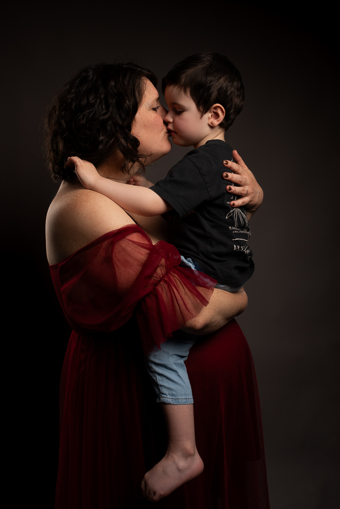 Maman enceinte portant son enfant lors d’une séance photo grossesse en studio à Morillon en Haute-Savoie