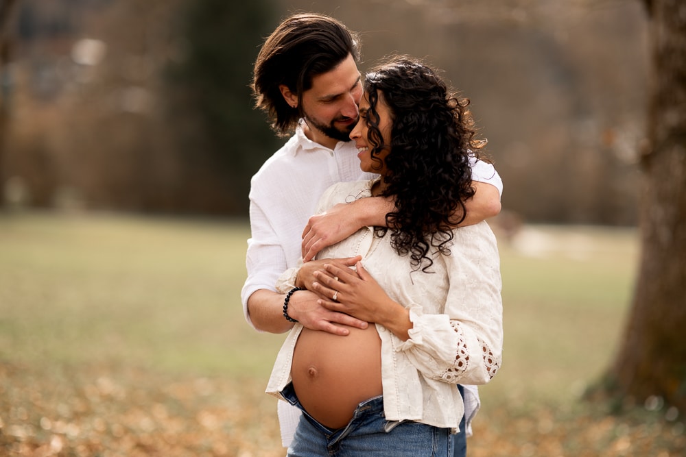 Séance grossesse en couple à Annemasse Photographe maternité Haute-Savoie Couple enlacé lors d’une séance photo grossesse naturelle en extérieur à Annemasse en Haute-Savoie