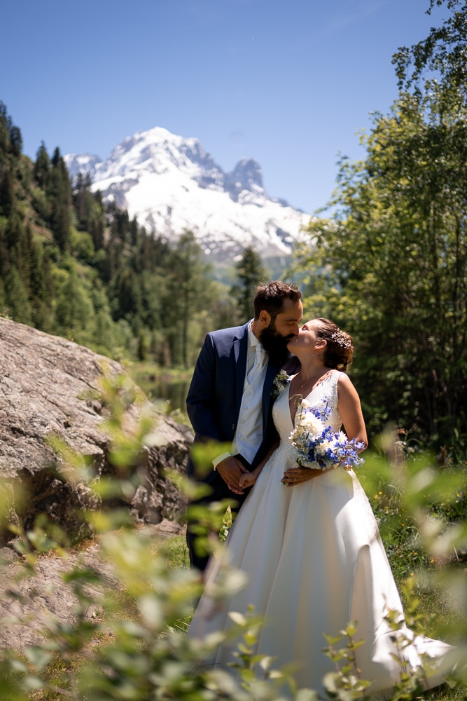 Couple de mariés s’embrassant face au Mont-Blanc lors d’une séance photo de mariage à Chamonix en Haute-Savoie.