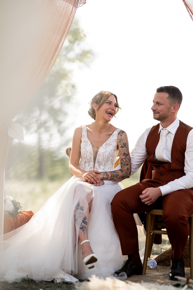 Instant d’émotion pendant une cérémonie de mariage-5 Les mariés échangent un regard complice et un éclat de rire pendant leur cérémonie laïque en Haute-Savoie, photographiés par une photographe de mariage à Samoëns.