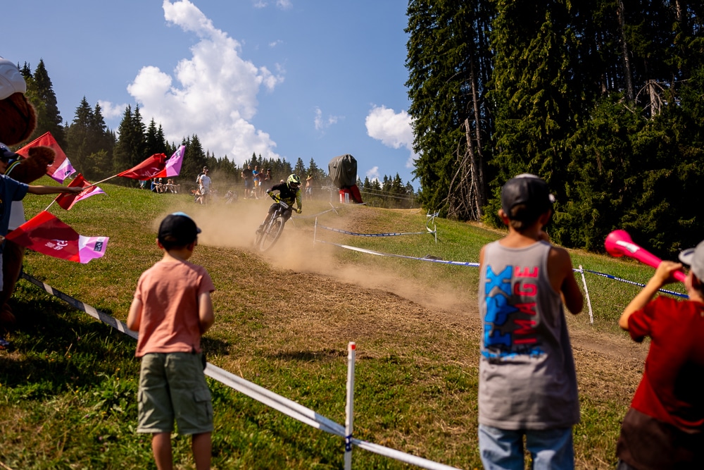 enduro-world-cup-haute-savoie-course-montagne-reportage-sportif Spectateurs encourageant un pilote de VTT pendant l’Enduro World Cup à Morillon en Haute-Savoie